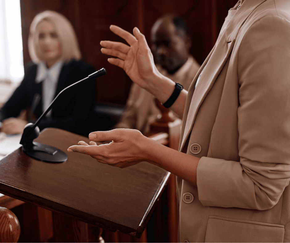 Person standing in court giving a testimony [expert opinion], Judge overlooking