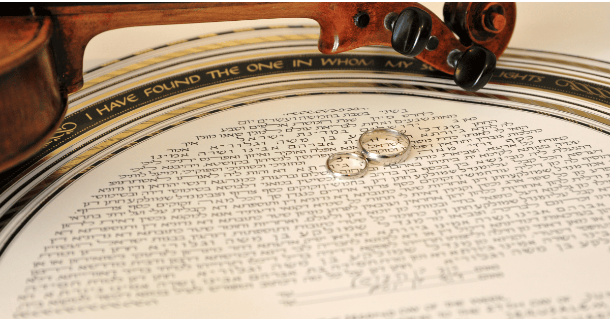 A decorated ketubah with Hebrew text, two wedding rings resting on it